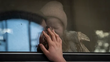 Ucranianos desplazados en un tren con destino a Polonia se despiden en Leópolis, Ucrania occidental, el martes 22 de marzo de 2022
