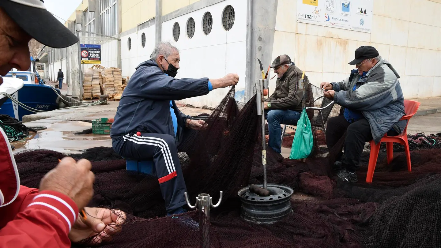 Varios pescadores arreglan los aparejos en el puerto de Almería mientras se desarrolla una manifestación de la flota de los puertos pesqueros Varios pescadores arreglan los aparejos en el puerto de Almería mientras se desarrolla una manifestación de la flota de los puertos pesqueros