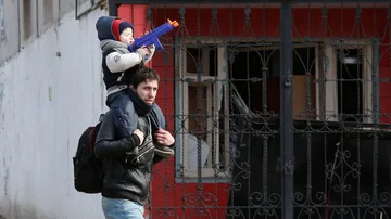 Un padre y su hijo con un arma de juguete en Mariúpol