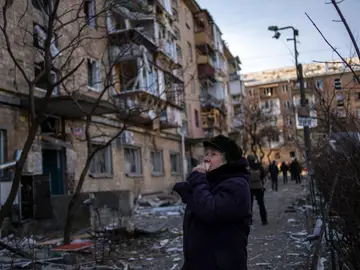 Una mujer mira un edificio residencial bombardeado en Kiev, Ucrania, el viernes 18 de marzo de 2022.