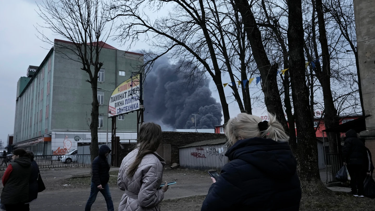 Ciudadanos de Leópolis observan el humo negro de las explosiones tras el bombardeo de la ciudad. Ciudadanos de Leópolis observan el humo negro de las explosiones tras el bombardeo de la ciudad.