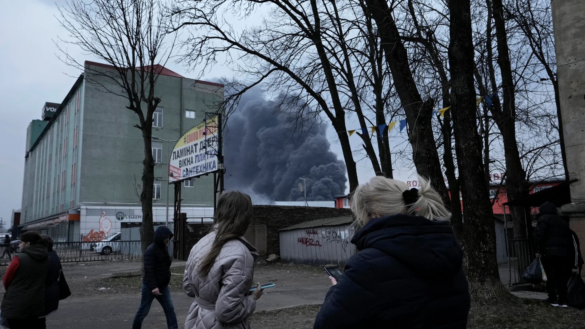 Ciudadanos de Leópolis observan el humo negro de las explosiones tras el bombardeo de la ciudad.