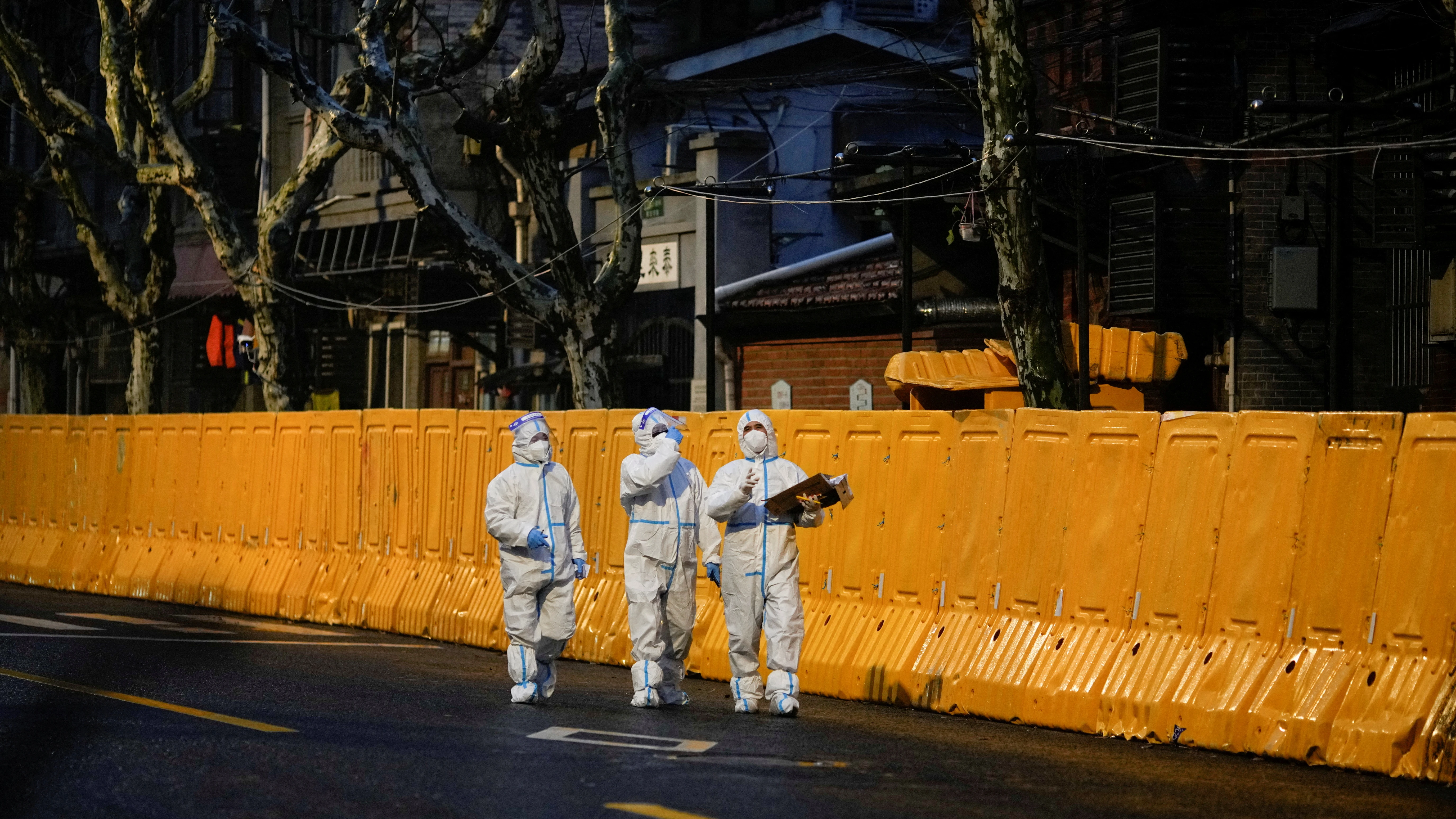 Sanitarios pasean por las calles de Shanghai tras el brote por omicron