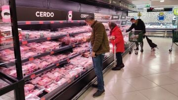Varias personas eligen entre la oferta de carnicería de un supermercado madrileño.