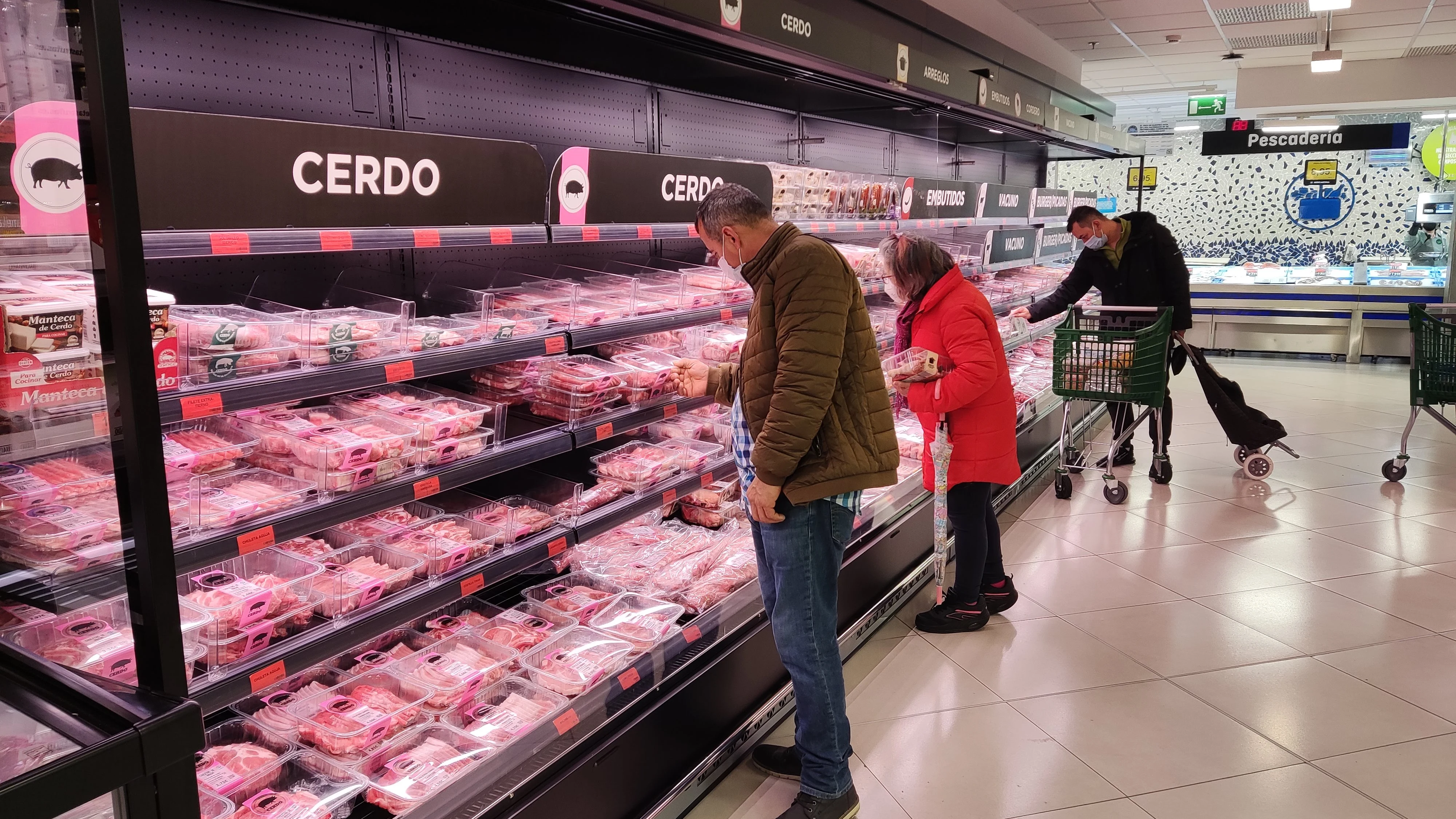 Varias personas eligen entre la oferta de carnicería de un supermercado madrileño.