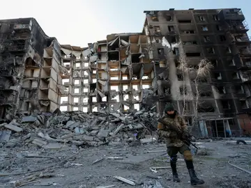 Un soldado prorruso camina frente a un edificio destruido en Mariúpol.