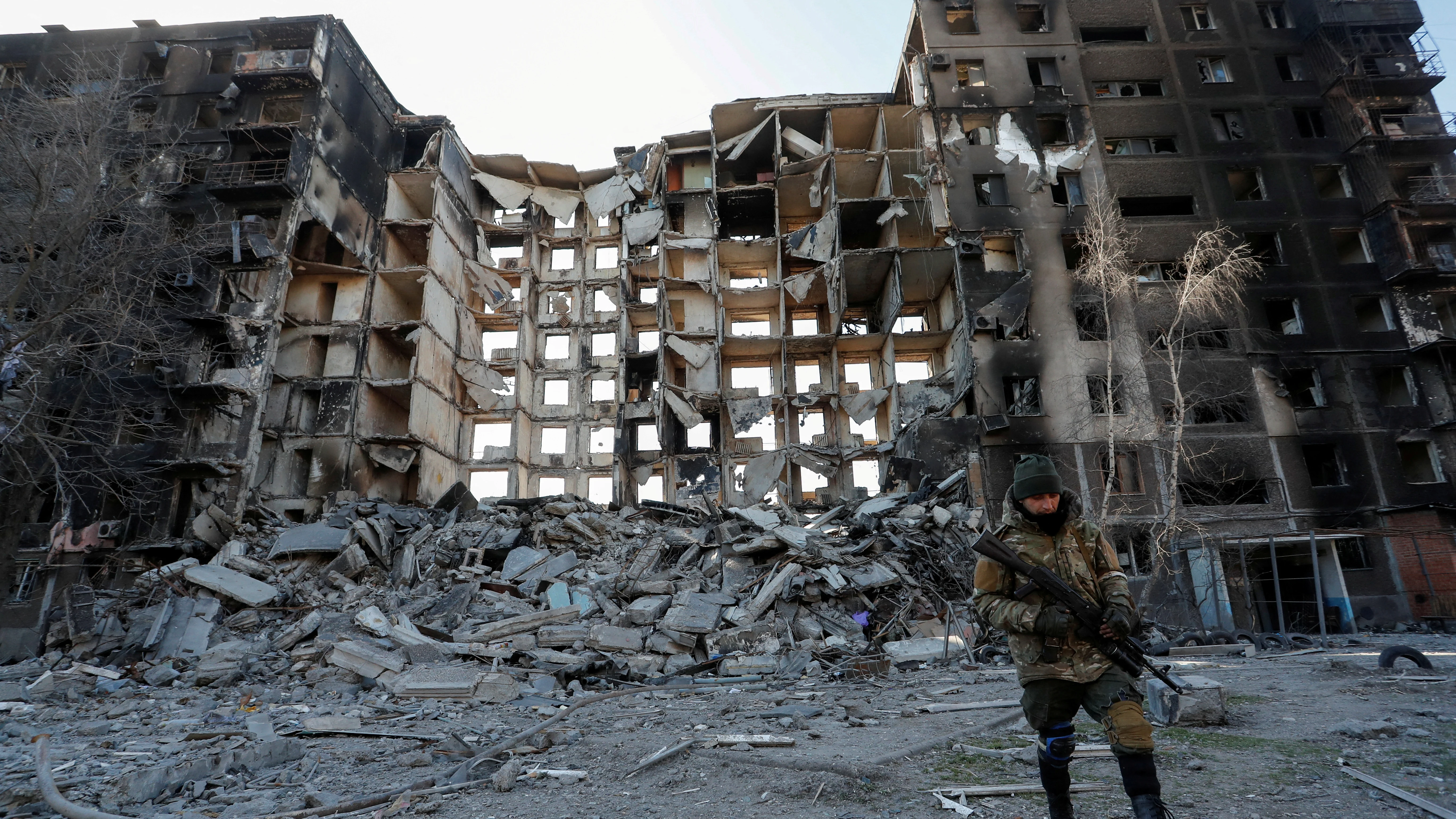 Un soldado prorruso camina frente a un edificio destruido en Mariúpol.