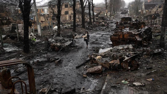 Una mujer camina entre tanques rusos destruidos en Bucha, en las afueras de Kiev, Ucrania Una mujer camina entre tanques rusos destruidos en Bucha, en las afueras de Kiev, Ucrania