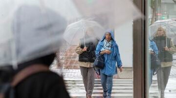 Dos mujeres se protegen de la lluvia en Murcia.