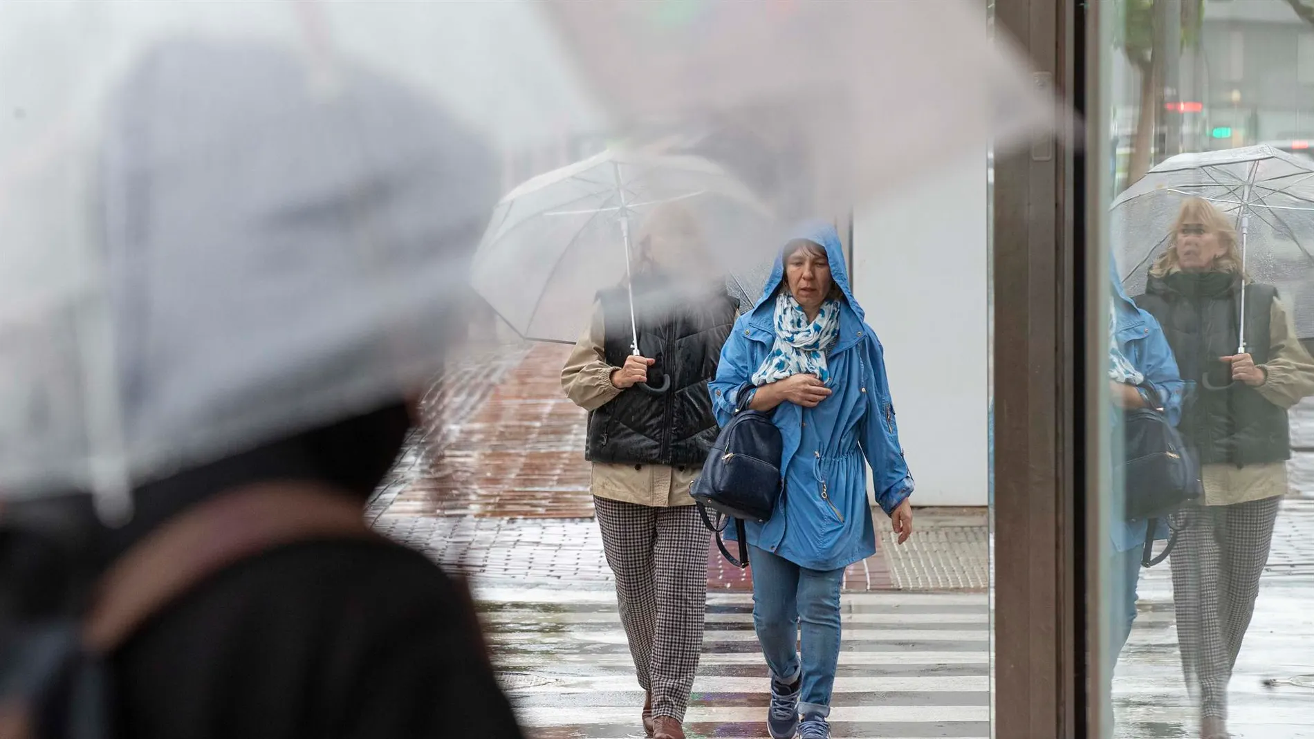 Dos mujeres se protegen de la lluvia en Murcia.