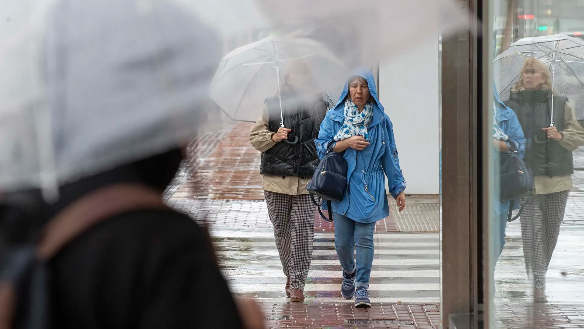 Dos mujeres se protegen de la lluvia en Murcia.