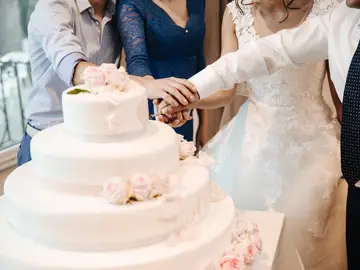 Imagen de archivo de una pareja cortando un pastel de boda