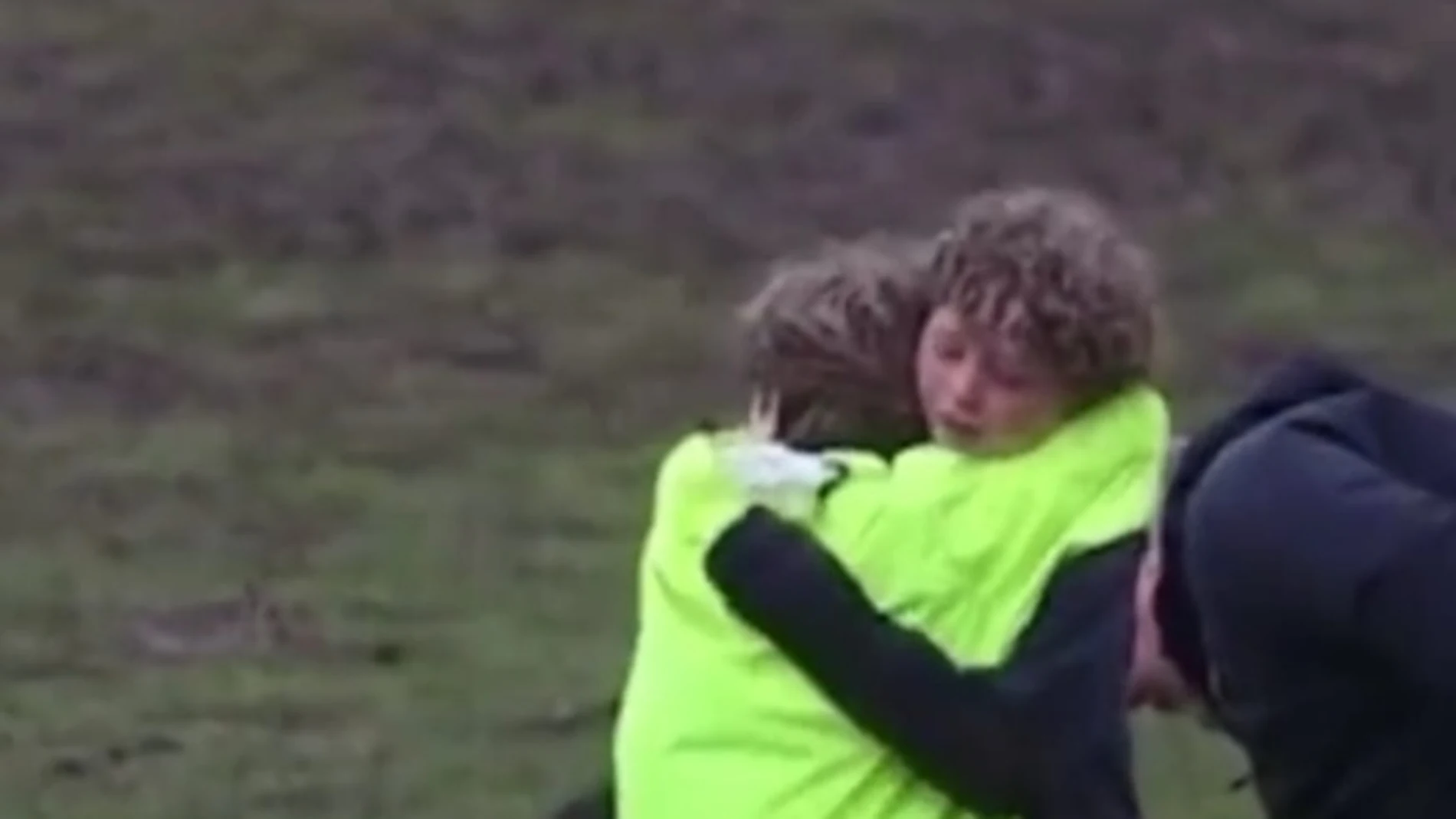 Dos niños se abrazan en un partido de rugby