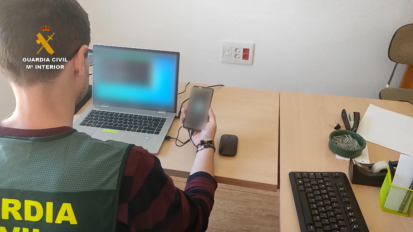 Un agente de la Guardia Civil interviene un teléfono móvil y ordenador en una foto de archivo Un agente de la Guardia Civil interviene un teléfono móvil y ordenador en una foto de archivo