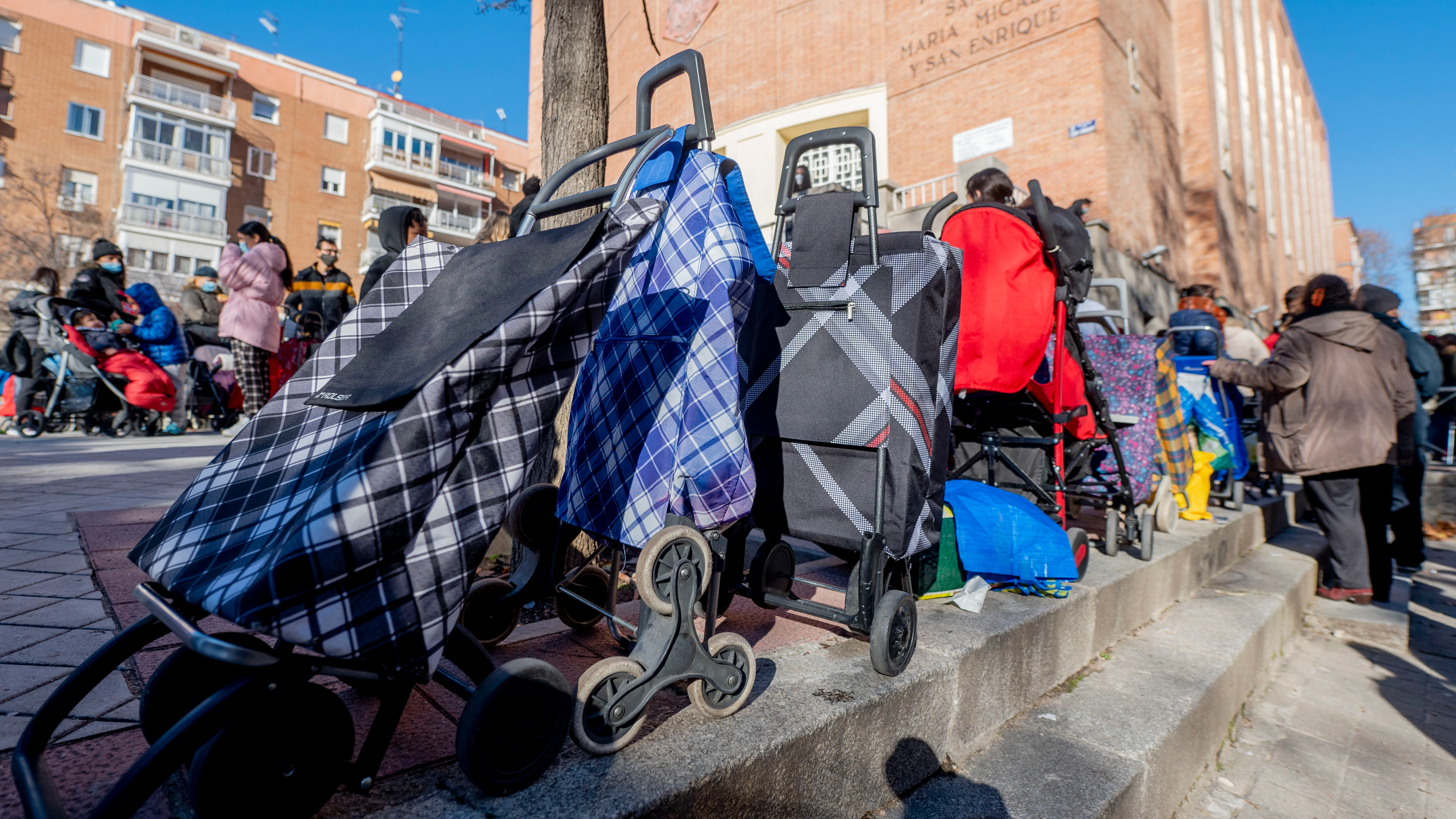 Varias personas hacen cola para recibir alimentos de la Fundación Madrina,