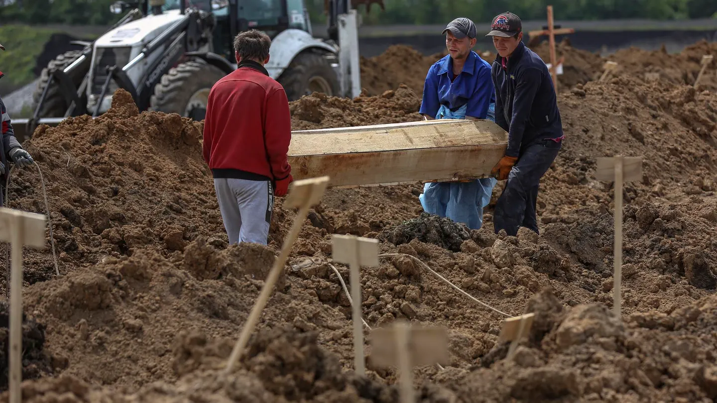 Trabajadores descargan un ataúd en un cementerio en el pueblo de Staryi Krym, a las afueras de Mariúpol. Trabajadores descargan un ataúd en un cementerio en el pueblo de Staryi Krym, a las afueras de Mariúpol.