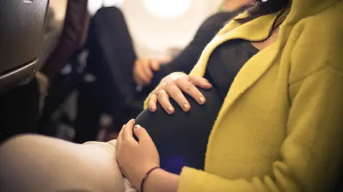 Mujer embarazada volando en avión Mujer embarazada volando en avión