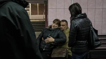  Un hombre abraza a una mujer para calmarla tras un ataque de misiles en el metro de Járkov.