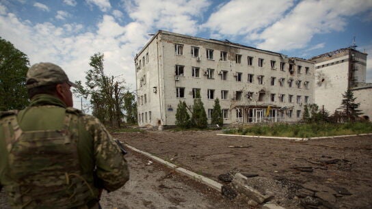 Un soldado pasa junto a un edificio en ruinas en Donetsk
