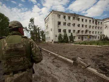 Un soldado pasa junto a un edificio en ruinas en Donetsk