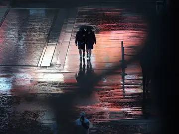 Personas caminan bajo la lluvia en París