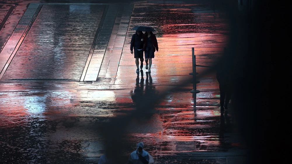 Personas caminan bajo la lluvia en París Personas caminan bajo la lluvia en París