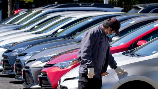 Un hombre observa una fila de coches Un hombre observa una fila de coches