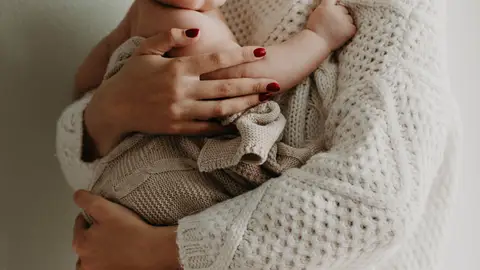 Bebé en brazos de su madre Bebé en brazos de su madre