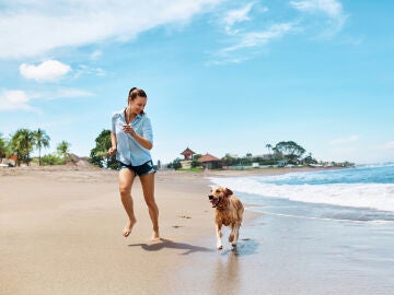Chica en la playa con el perro