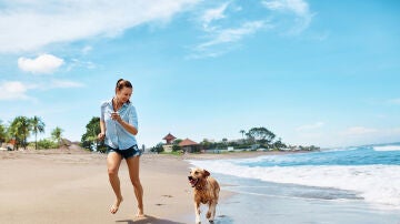 Chica en la playa con el perro