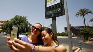 Dos personas se hacen un selfie frente a un termómetro que marca 44 grados en Córdoba 