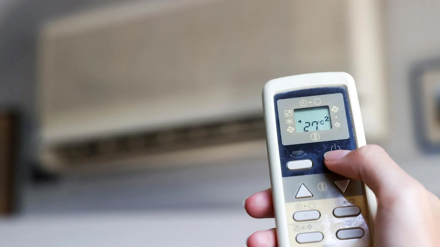 Imagen de archivo de una persona que enciende el aire acondicionado. La temperatura a la que debes poner el aire acondicionado para ahorrar más dinero en la factura de la luz