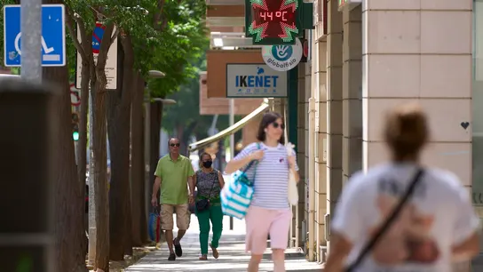 Varias personas pasean por una calle de Lleida durante la ola de calor Varias personas pasean por una calle de Lleida durante la ola de calor