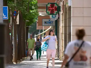 Varias personas pasean por una calle de Lleida durante la ola de calor 