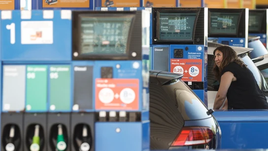 Una mujer echa gasolina a su coche Una mujer echa gasolina a su coche