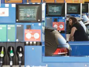 Una mujer echa gasolina a su coche