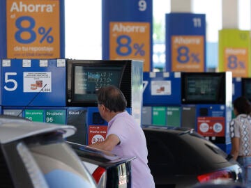 Dos personas repostan en una gasolinera de Madrid, en una imagen de archivo.