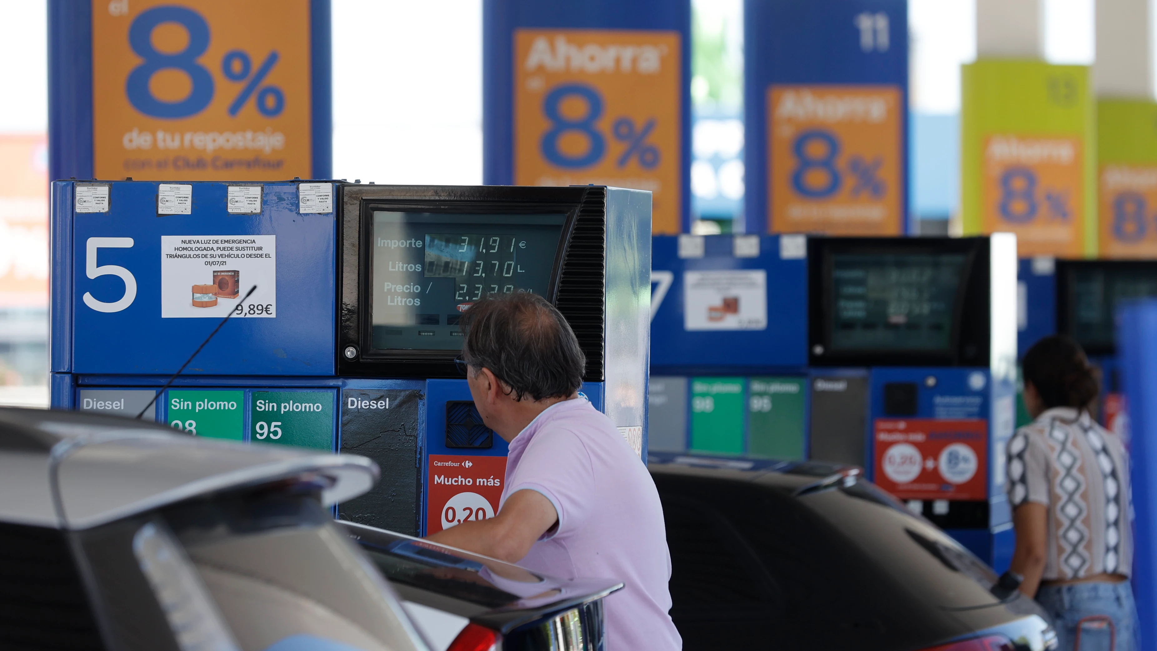 Dos personas repostan en una gasolinera de Madrid, en una imagen de archivo.