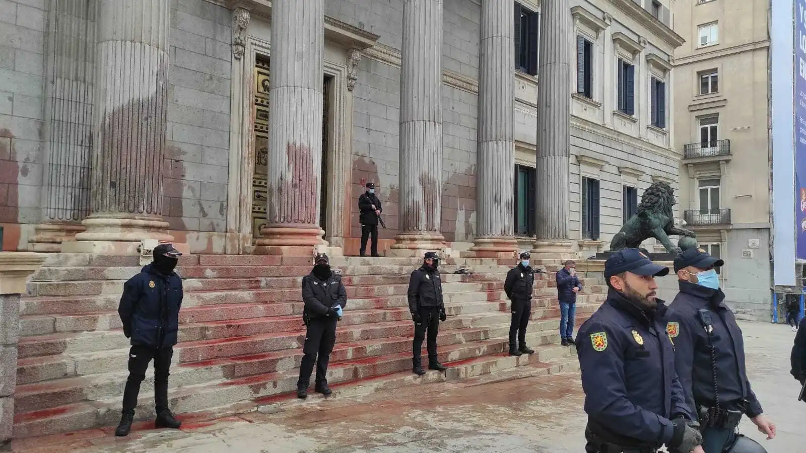 Agentes protegen la entrada al Congreso de los Diputados tras el lanzamiento de "agua teñida" por parte de activistas