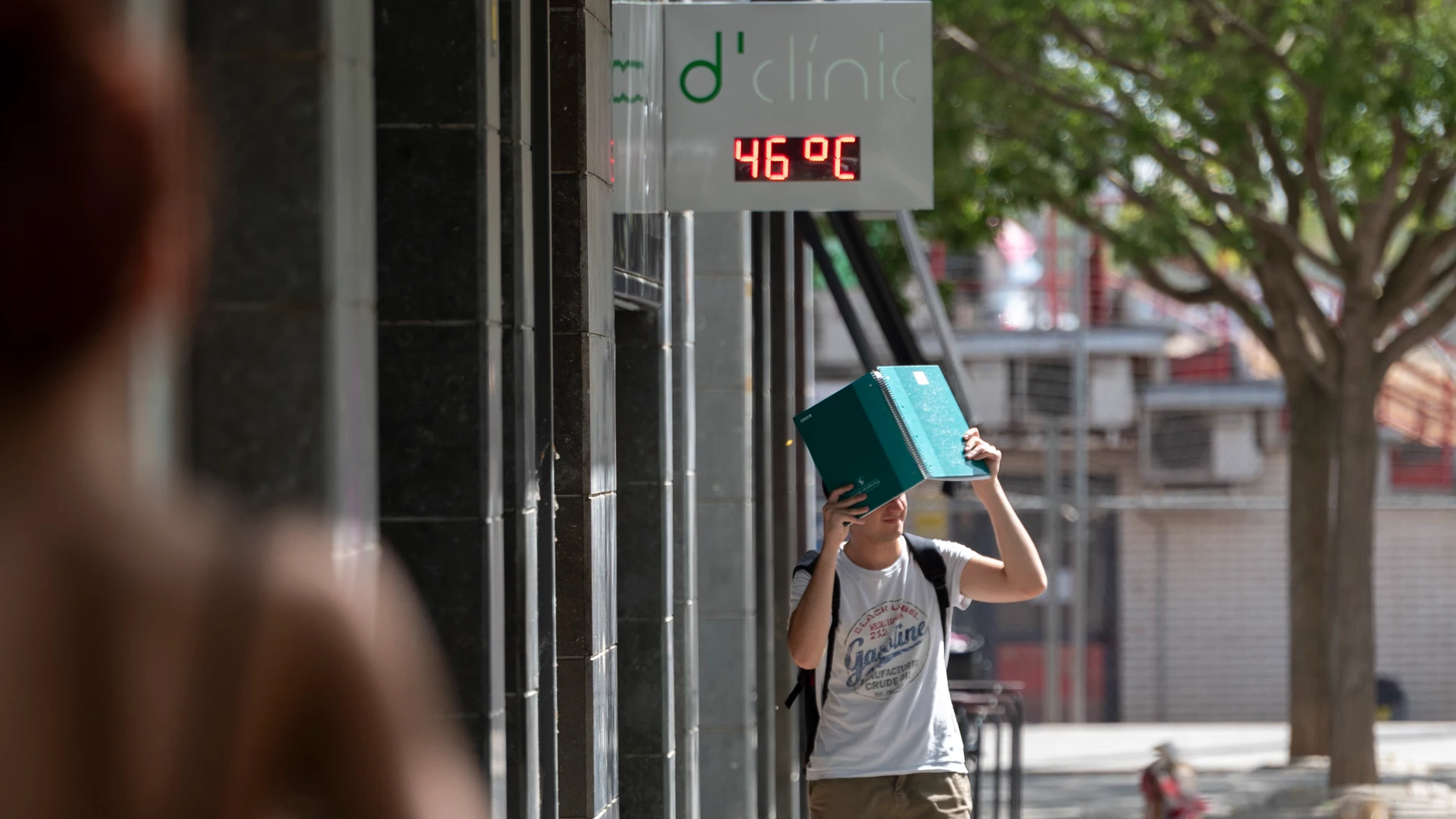 Un joven camina por una calle de Lleida, bajo un termómetro que indica los 47ºC este miércoles.