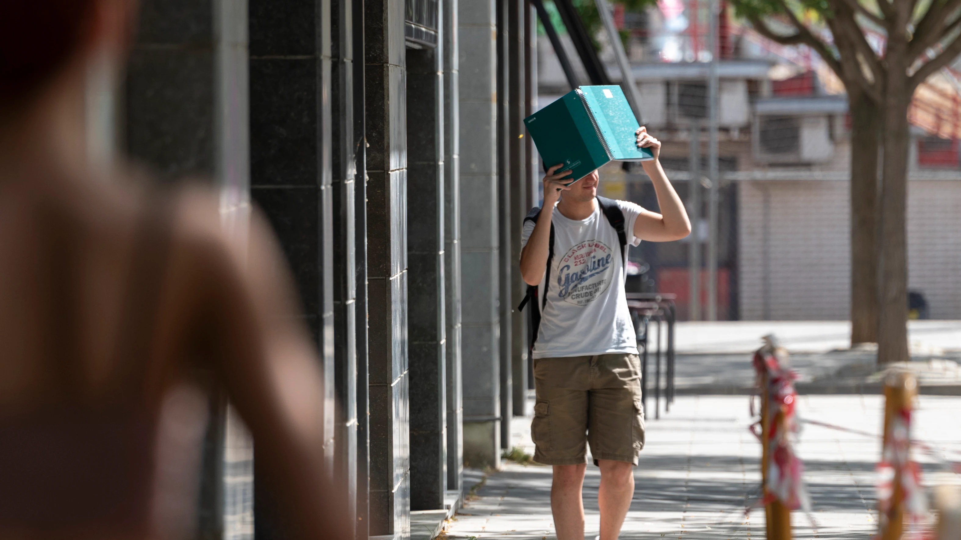 Un joven camina por una calle de Lleida, bajo un termómetro que indica los 47ºC este miércoles.