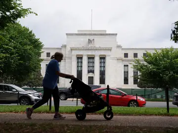 Una mujer pasea frente a la sede de la sede de la Reserva Federal en Washington