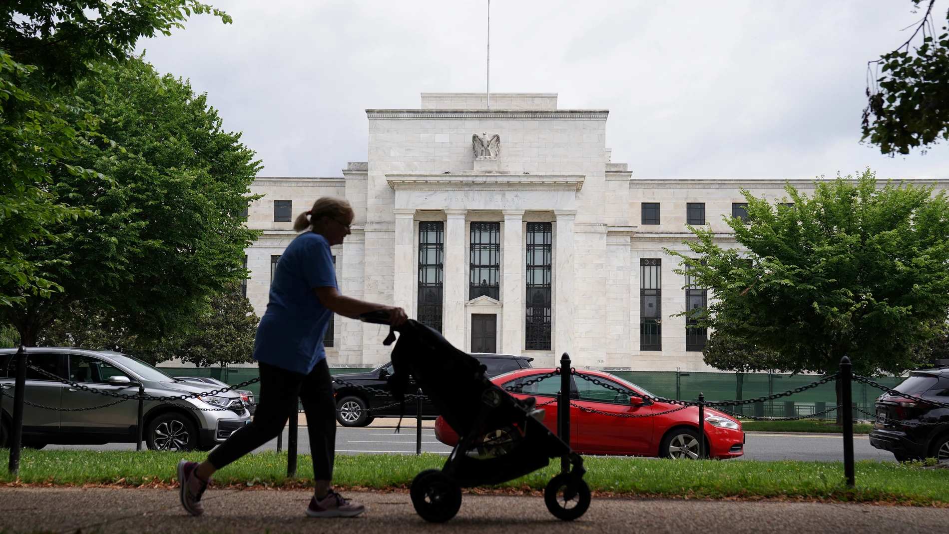 Una mujer pasea frente a la sede de la sede de la Reserva Federal en Washington