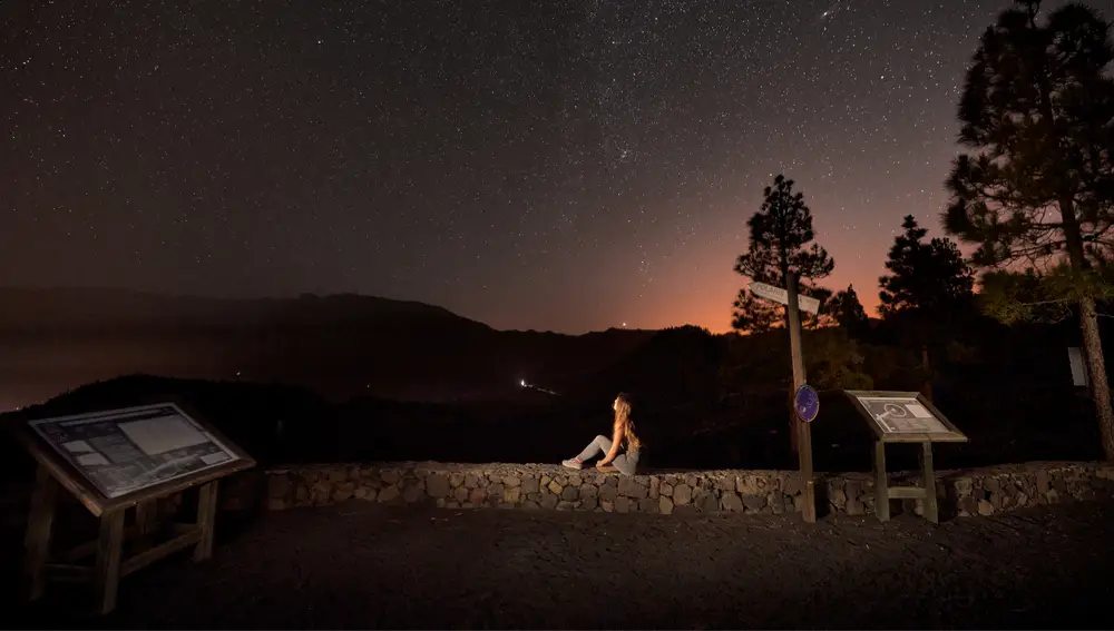Joven observa el cielo nocturno de Canarias