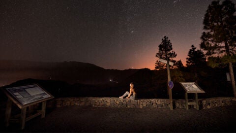 Joven observa el cielo nocturno de Canarias