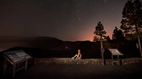 Joven observa el cielo nocturno de Canarias Joven observa el cielo nocturno de Canarias