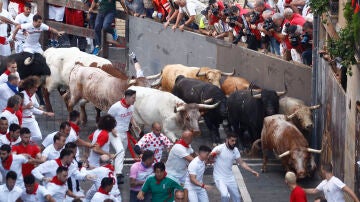 Los toros de la ganadería gaditana Núñez del Cuvillo a su llegada a la curva la calle de la Estafeta durante el primer encierro de los Sanfermines 2022