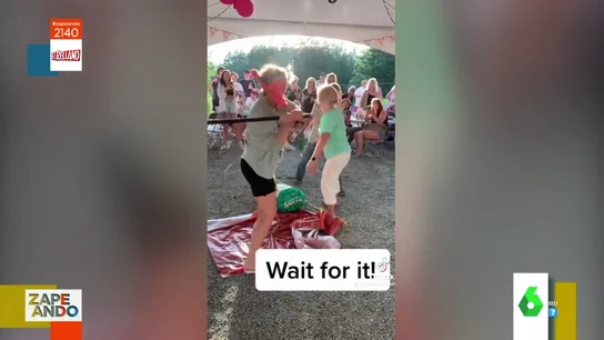 Una mujer recibe un golpe al colocar una piñata Una mujer recibe un golpe al colocar una piñata