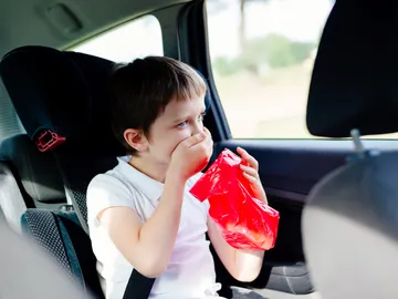 Un niño mareado y con ganas de vomitar en el coche. Un niño mareado y con ganas de vomitar en el coche.