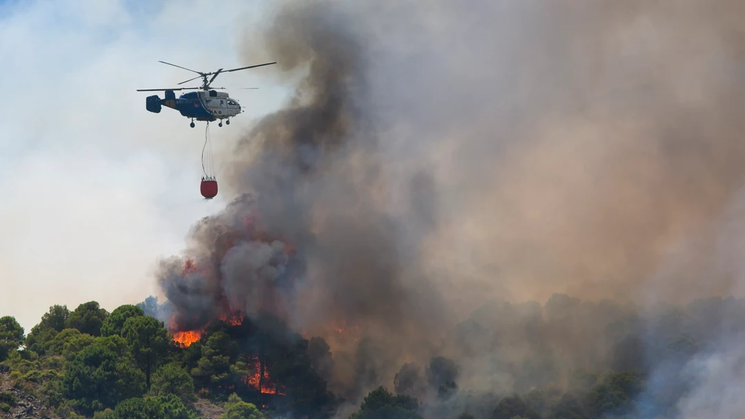 Un helicóptero del servicio de bomberos trabaja en el incendio declarado en la sierra de Mijas, Málaga